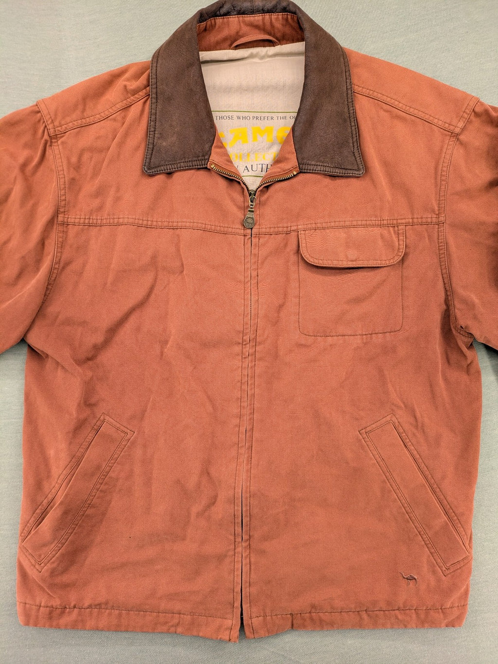 Camel Collection brown jacket with orange contrast collar and embroidered logo.