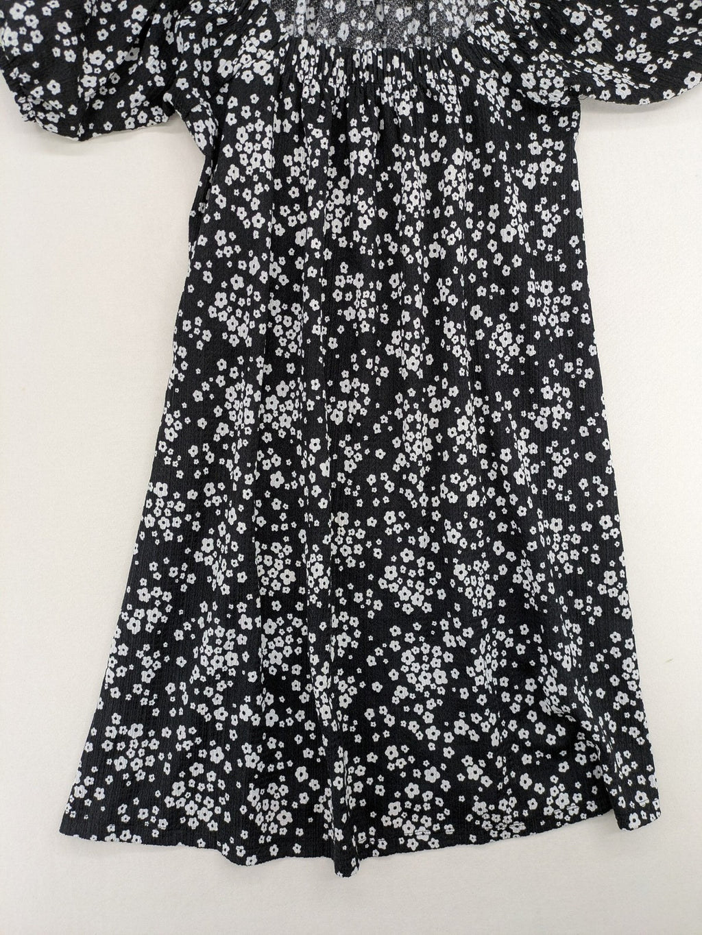 Clockhouse black and white floral mini dress with smocked bodice and puff sleeves.