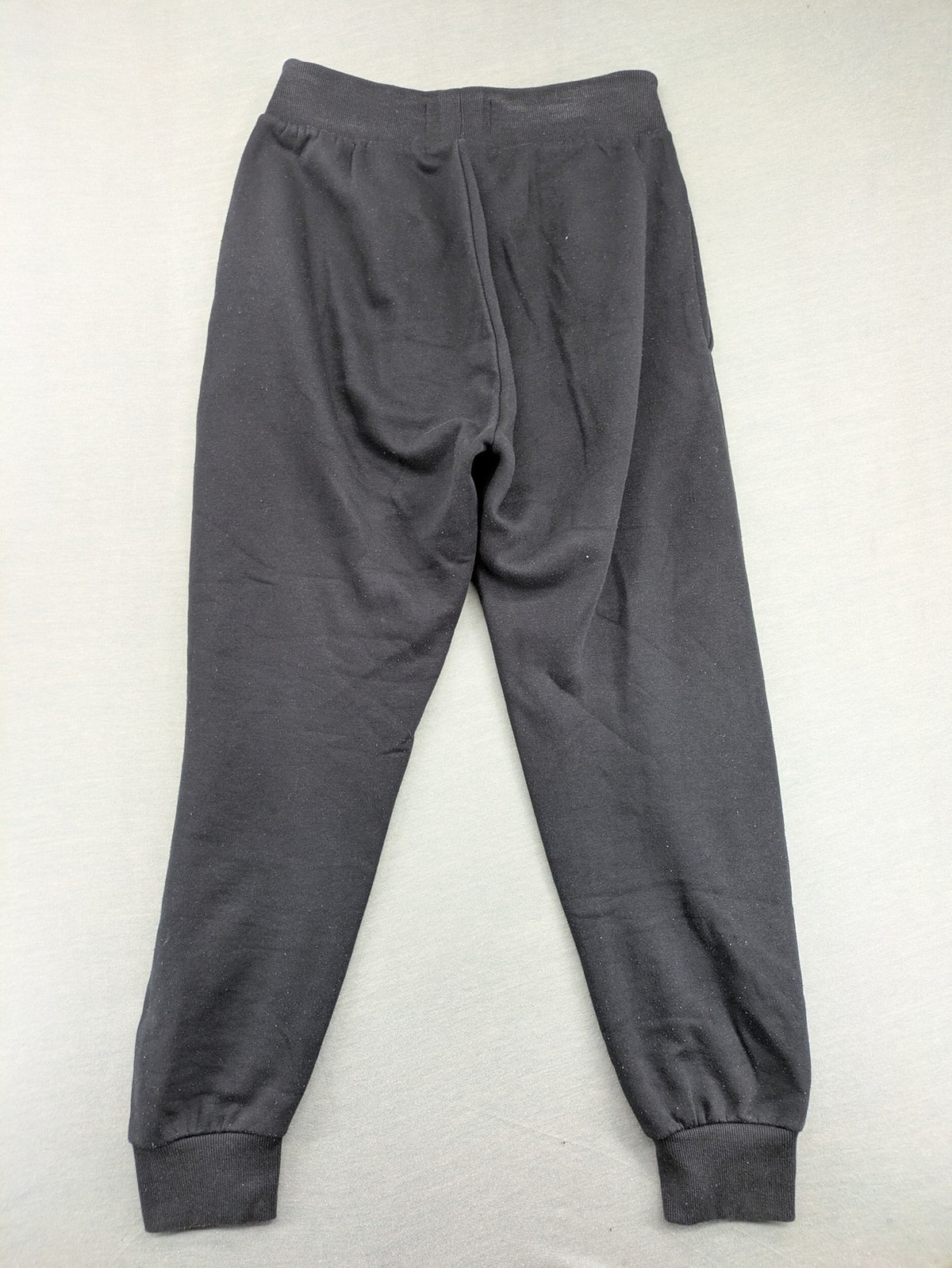 McKenzie black joggers with white logo, tapered fit, and ribbed ankle cuffs.