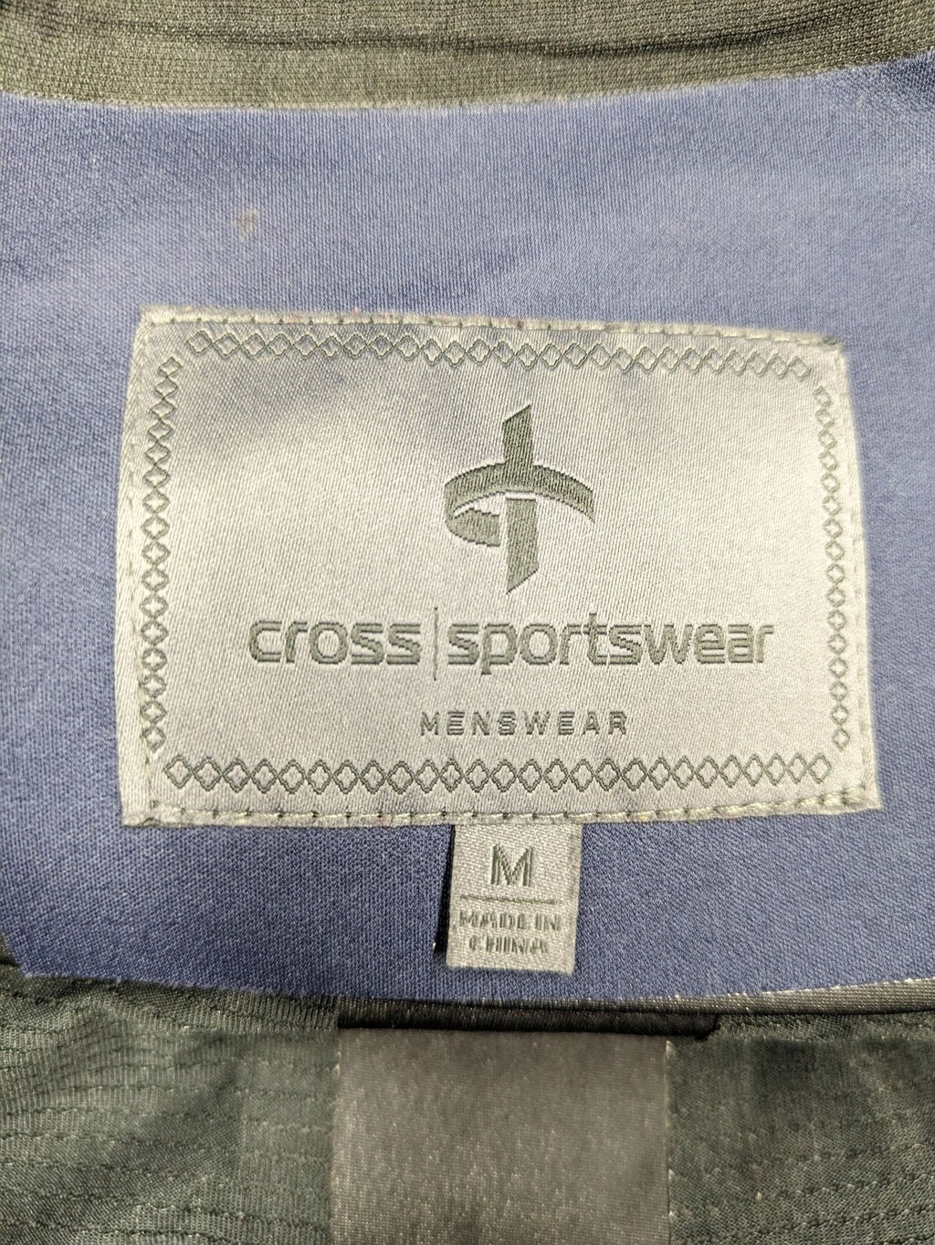 Cross Sportswear orange golf jacket with full zip, high collar, and contrast zipper details.