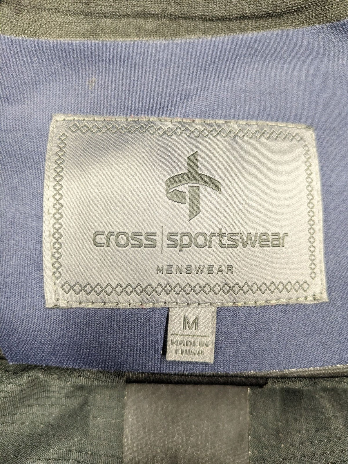 Cross Sportswear orange golf jacket with full zip, high collar, and contrast zipper details.