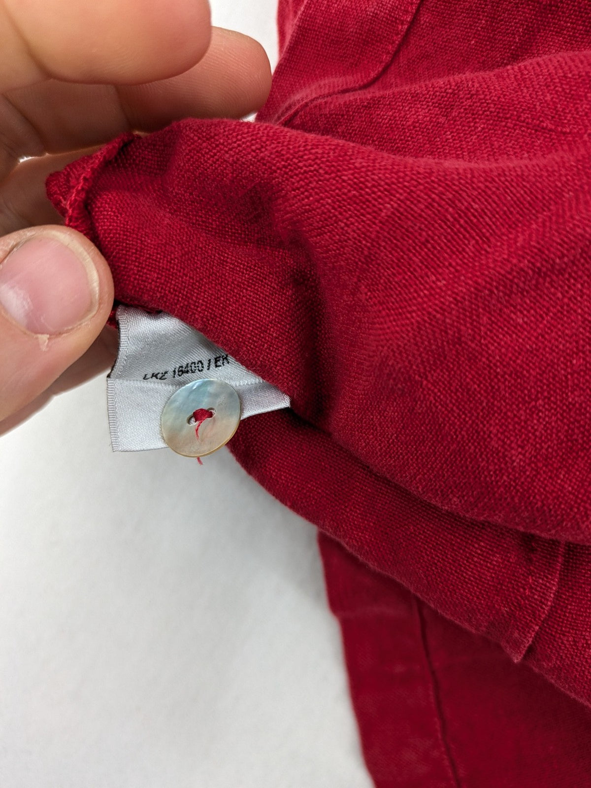 Deerberg red short-sleeve linen blouse with collar, button placket, and side slits.