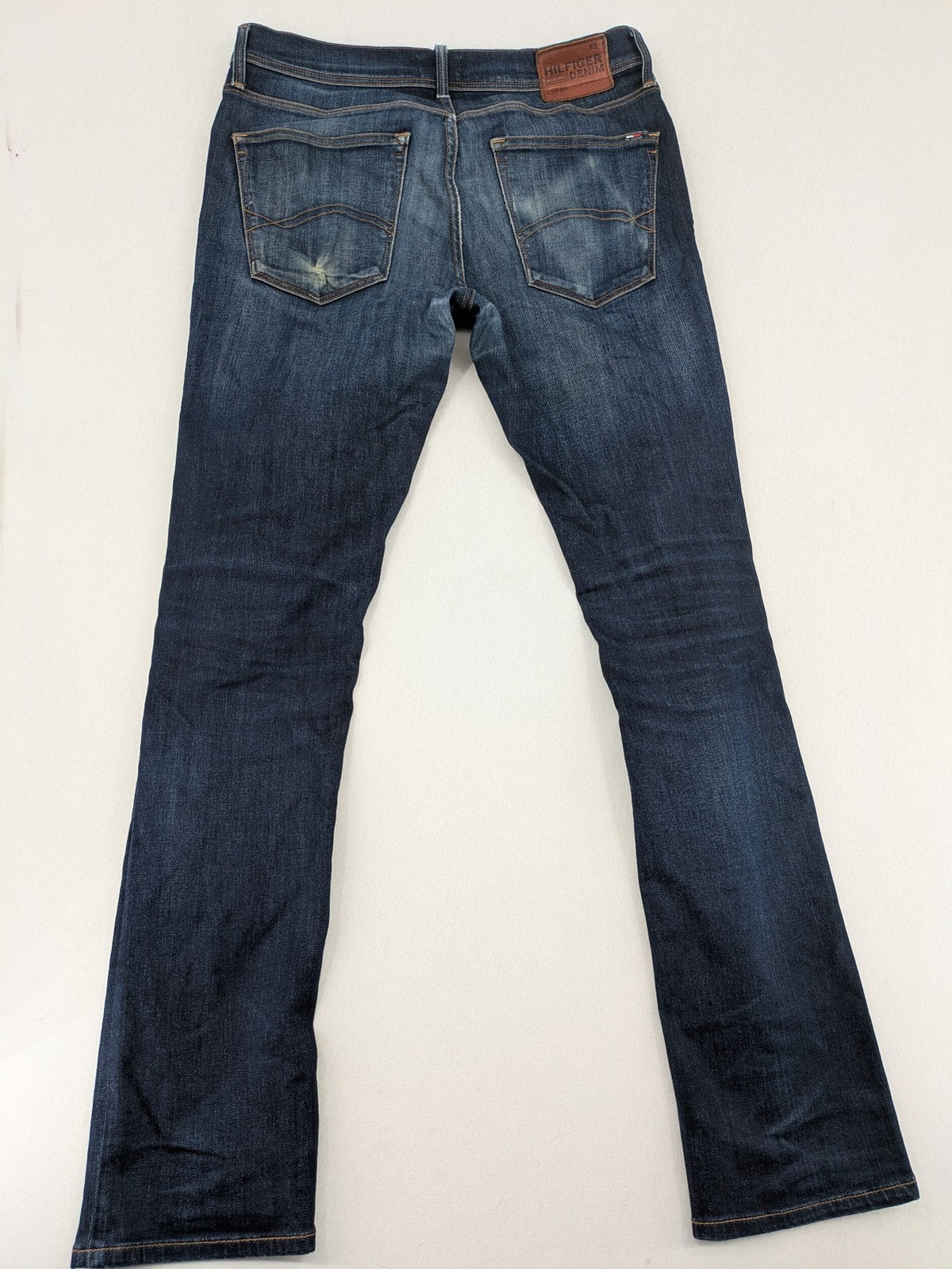 Tommy Hilfiger Denim blue straight jeans with five-pocket design and natural fading details.