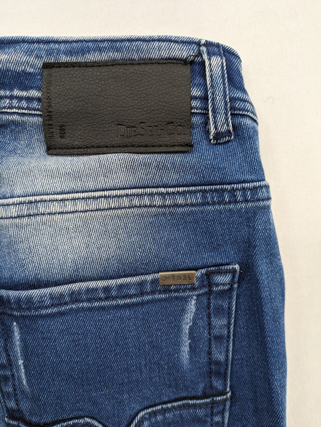 Diesel blue straight jeans with distressed details and ripped accents, made of cotton.