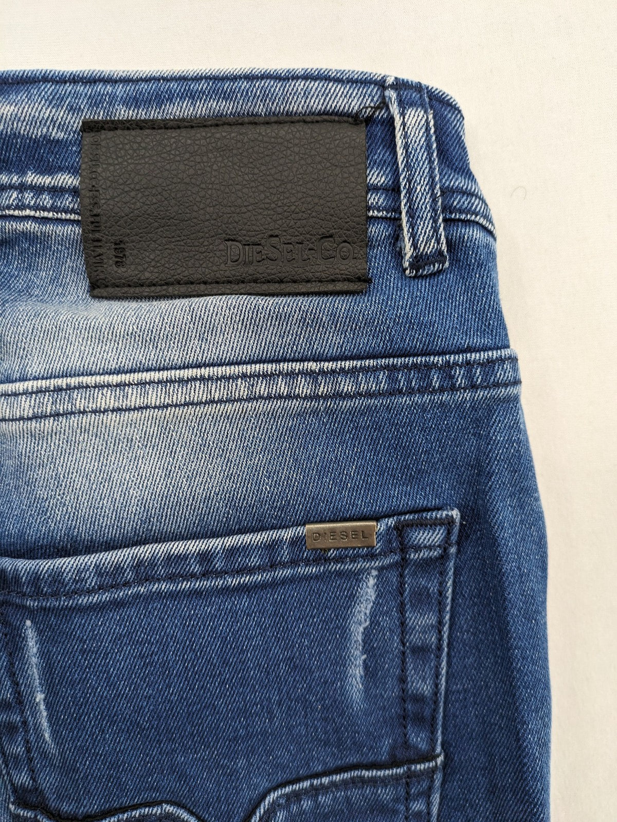 Diesel blue straight jeans with distressed details and ripped accents, made of cotton.