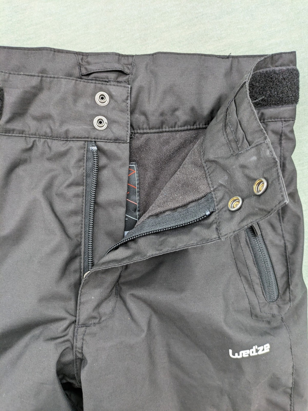 Wed'ze black ski pants with adjustable waistband, zip pockets, and Pull'n'Fit system.