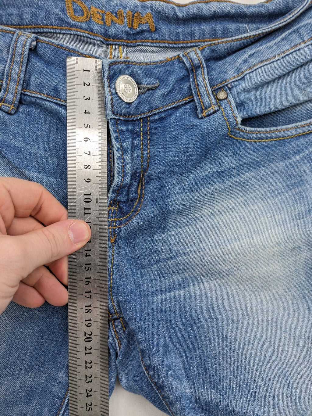 Denim blue straight jeans low rise bootcut with classic 5-pocket design and subtle rivets.
