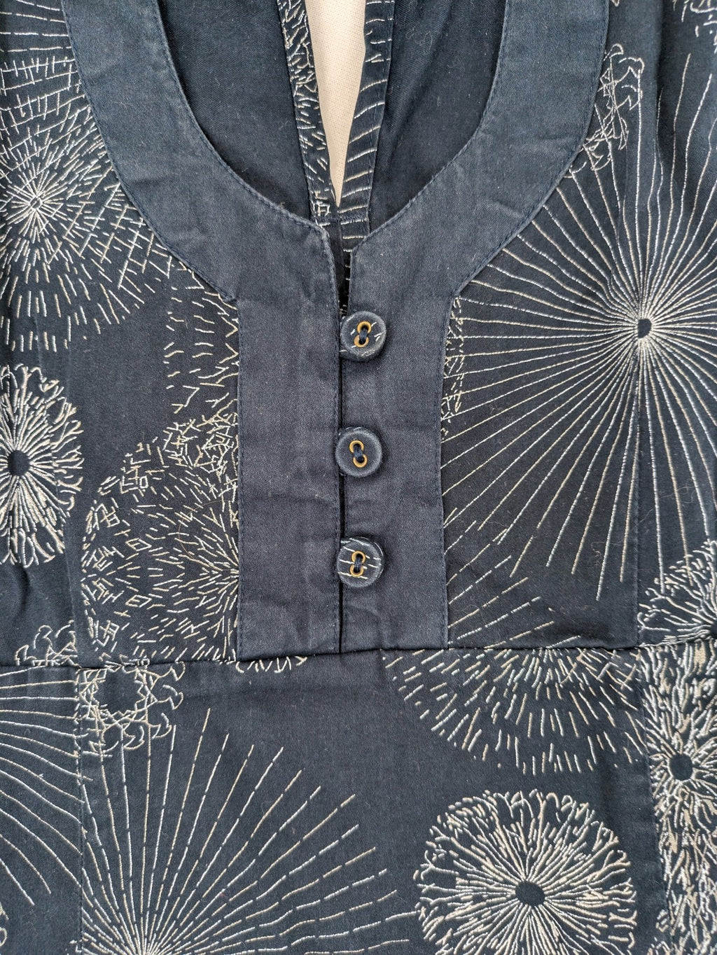 Muster navy dress with white abstract dandelion print, V-neck and collar details.