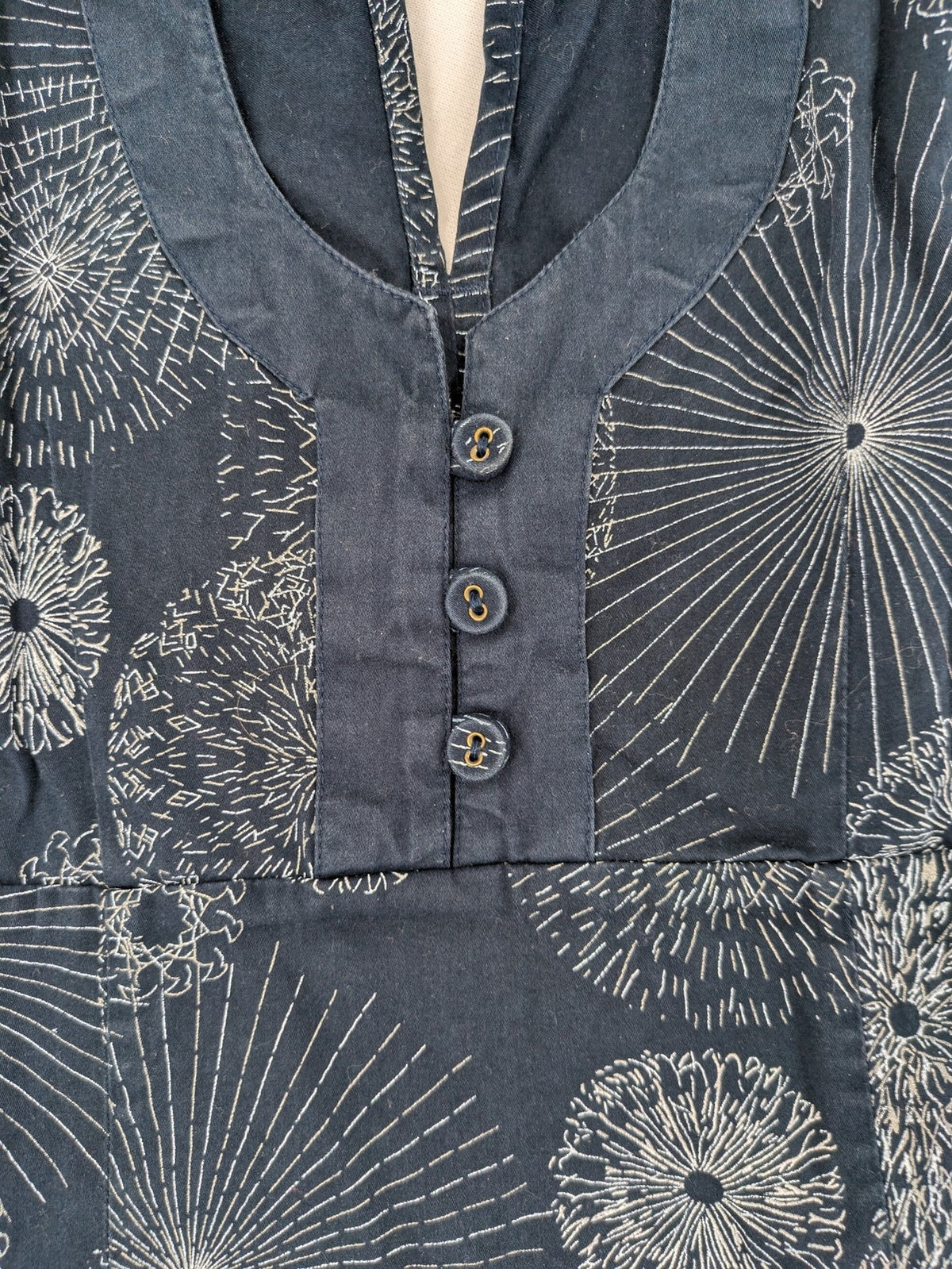 Muster navy dress with white abstract dandelion print, V-neck and collar details.