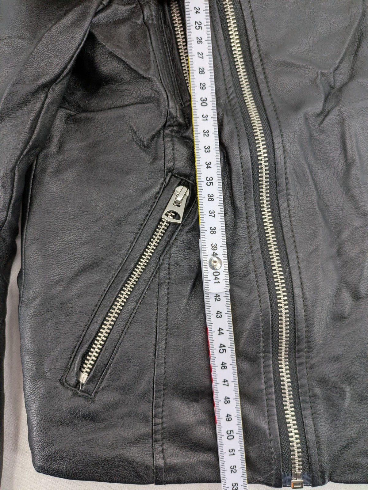 H&M black biker jacket with silver zippers, shoulder flaps, and snap-button details.