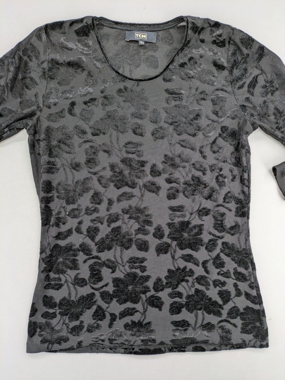 TCM black long sleeve top with floral flock print on sheer fabric.