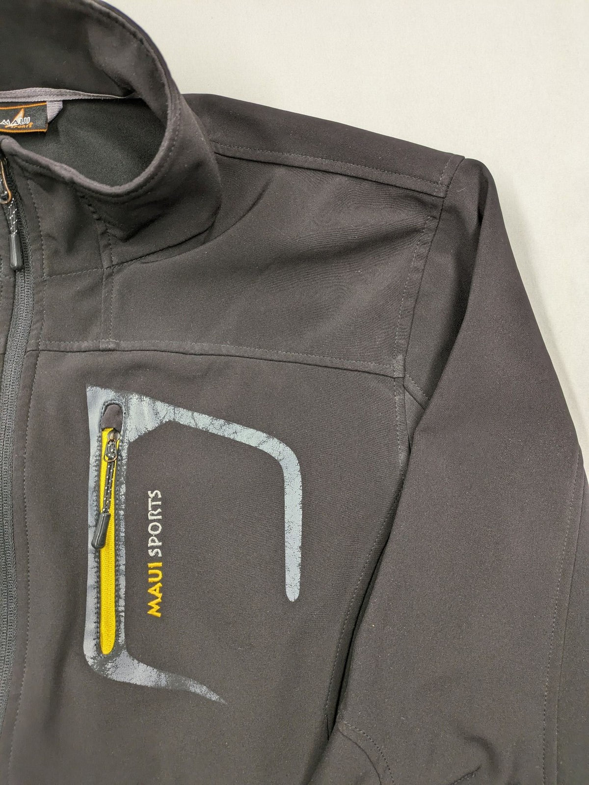 Maui Sports grey softshell jacket XL with contrasting yellow zipper and multiple pockets.