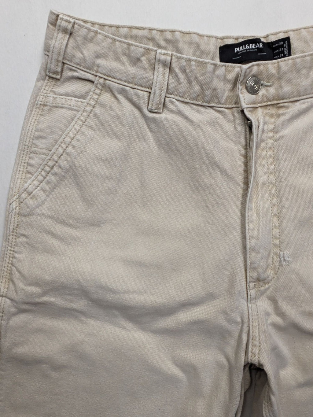 Pull&Bear beige carpenter pants with classic zipper, belt loops, and durable cotton material.