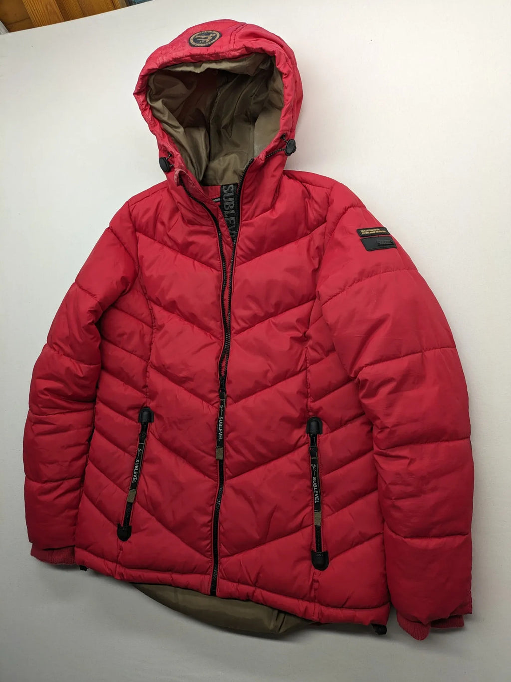 Sublevel red puffer jacket size S, chevron quilted pattern, adjustable hood, recycled polyester lining.