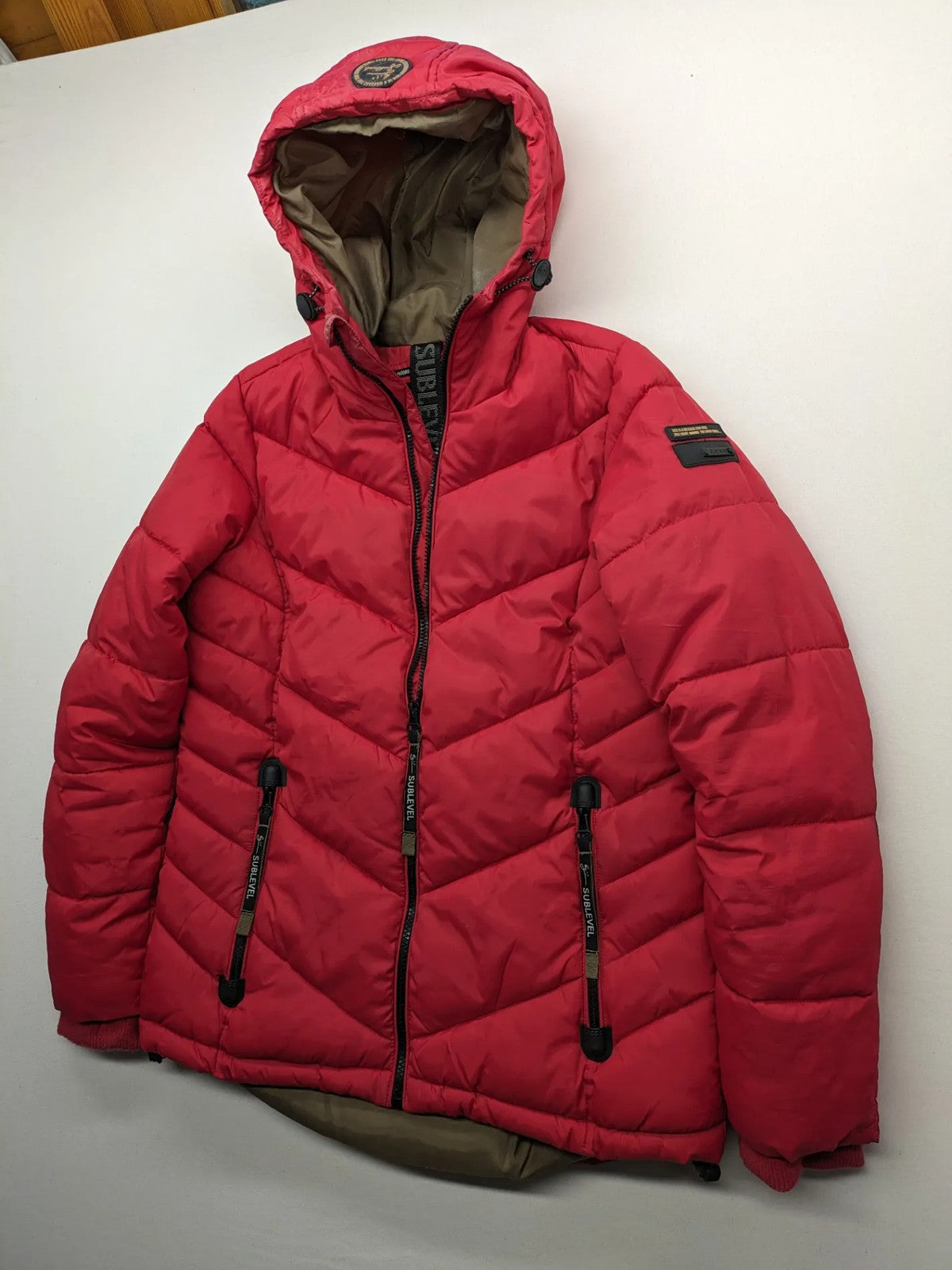 Sublevel red puffer jacket size S, chevron quilted pattern, adjustable hood, recycled polyester lining.