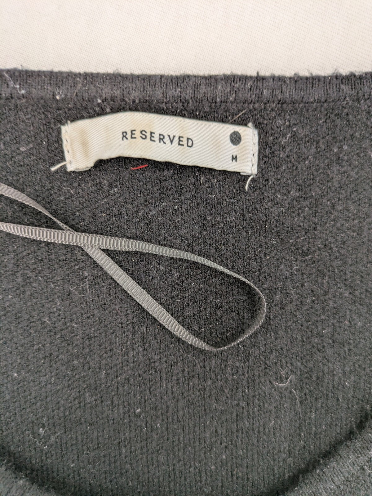 Reserved gold turtle neck jumper with black knit, gold button details and front pockets.