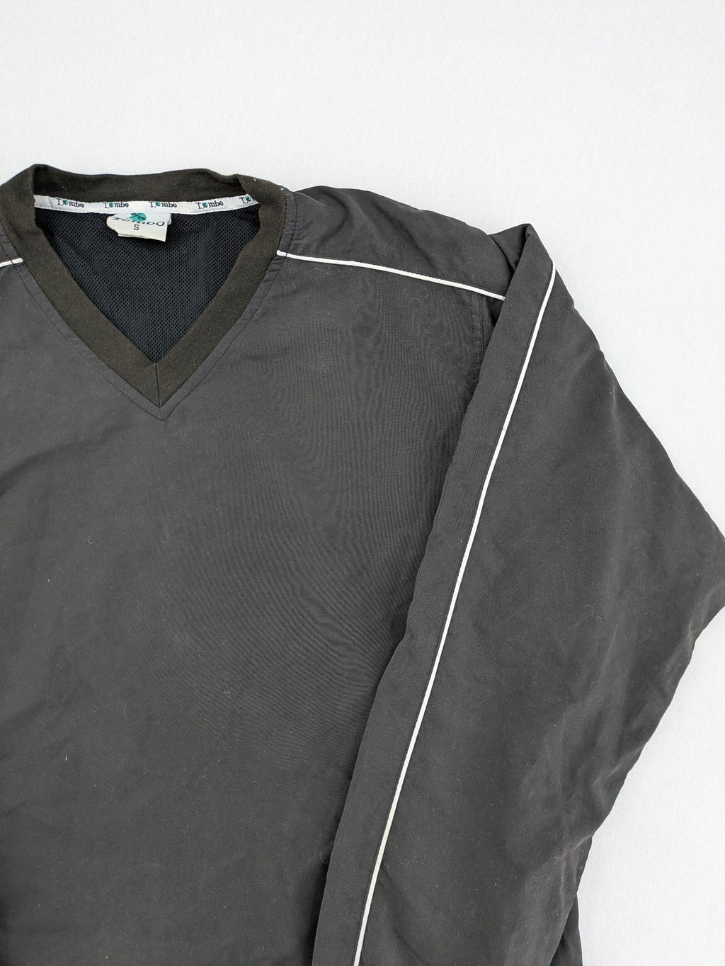 Tombo green windbreaker jacket with white piping, V-neck, and zippered pockets.