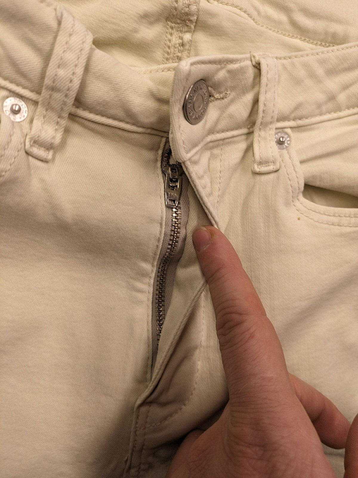 Tommy Jeans beige high rise skinny ankle jeans with logo patch and stretch fabric.