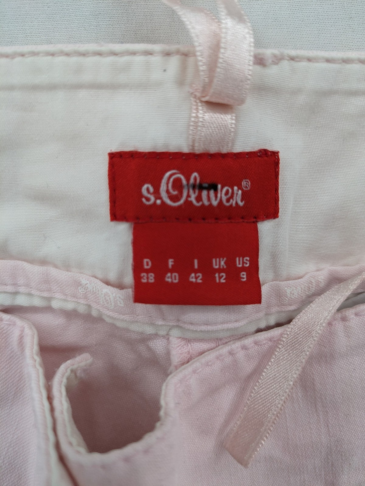 s.Oliver green bootcut pants with front pockets and button details, made of cotton-elastane blend.