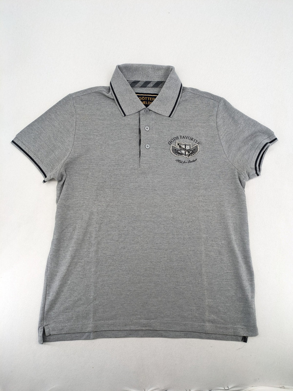 Götter & Helden grey polo shirt with "Gods Favorite" embroidery and contrasting collar details.