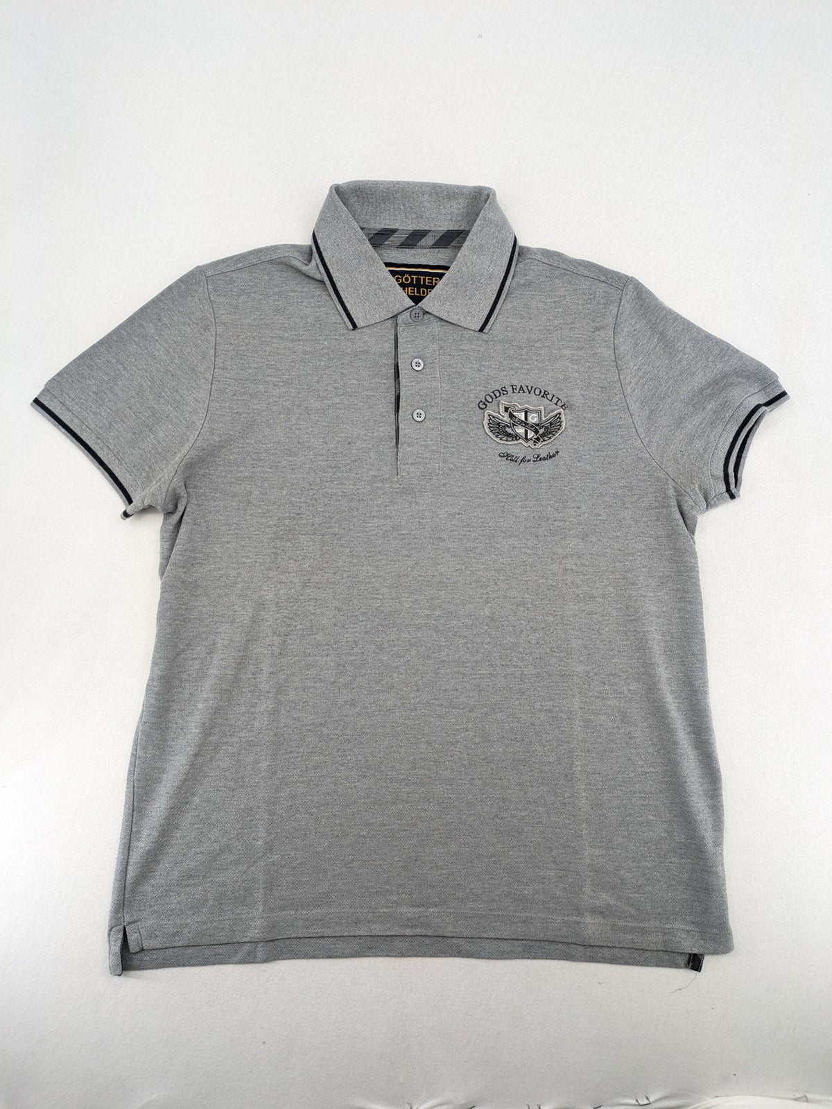 Götter & Helden grey polo shirt with "Gods Favorite" embroidery and contrasting collar details.