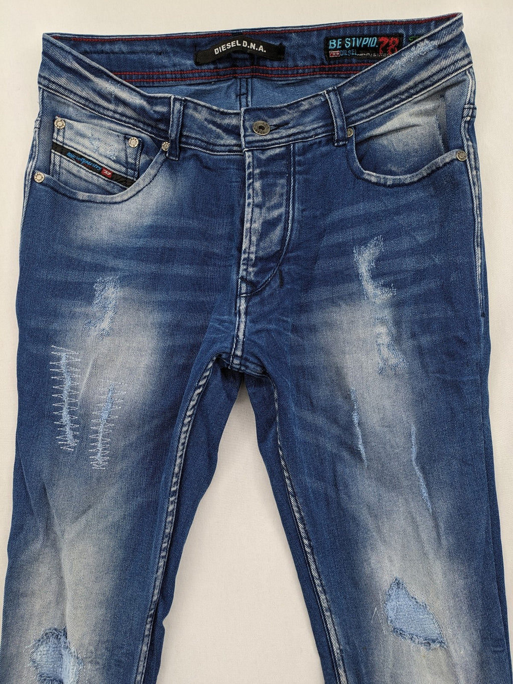 Diesel blue straight jeans with distressed details and ripped accents, made of cotton.