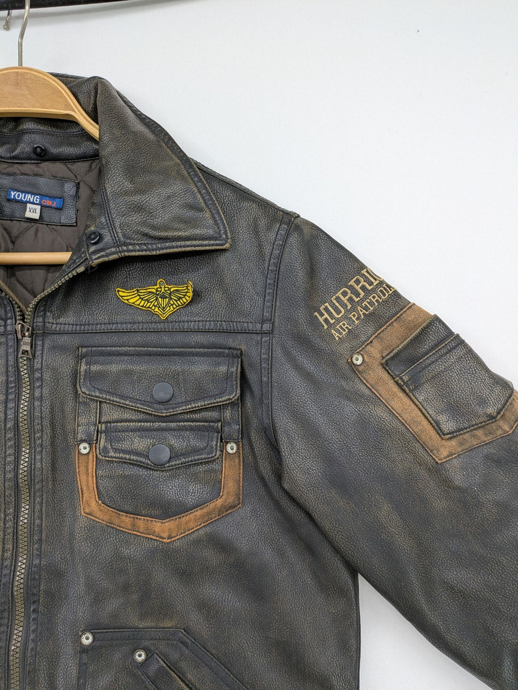 Junge brown bomber jacket with vintage patches and embroidered details in faux leather.