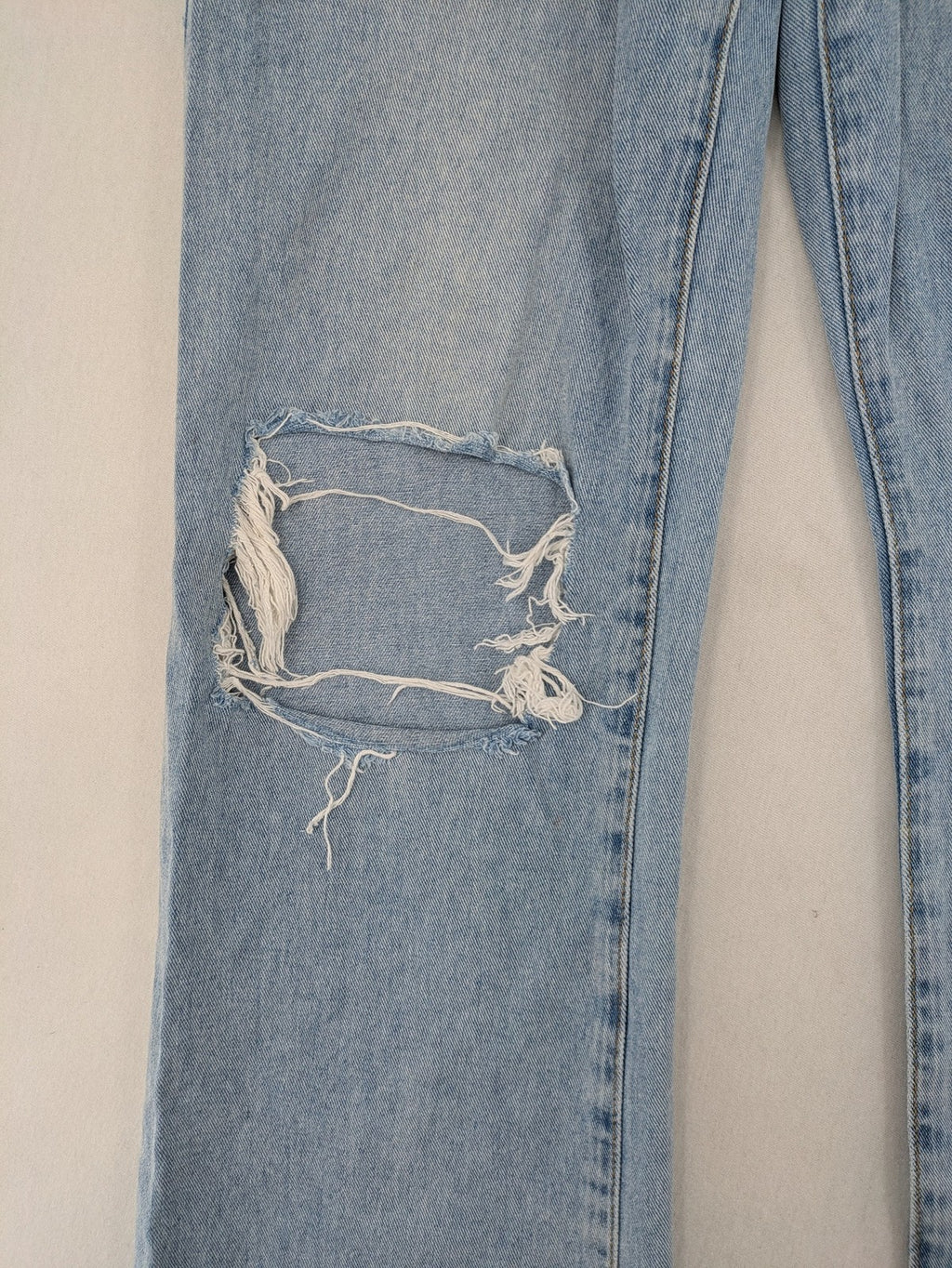 Laulia blue wide leg jeans with distressed knee rips and high waist design.