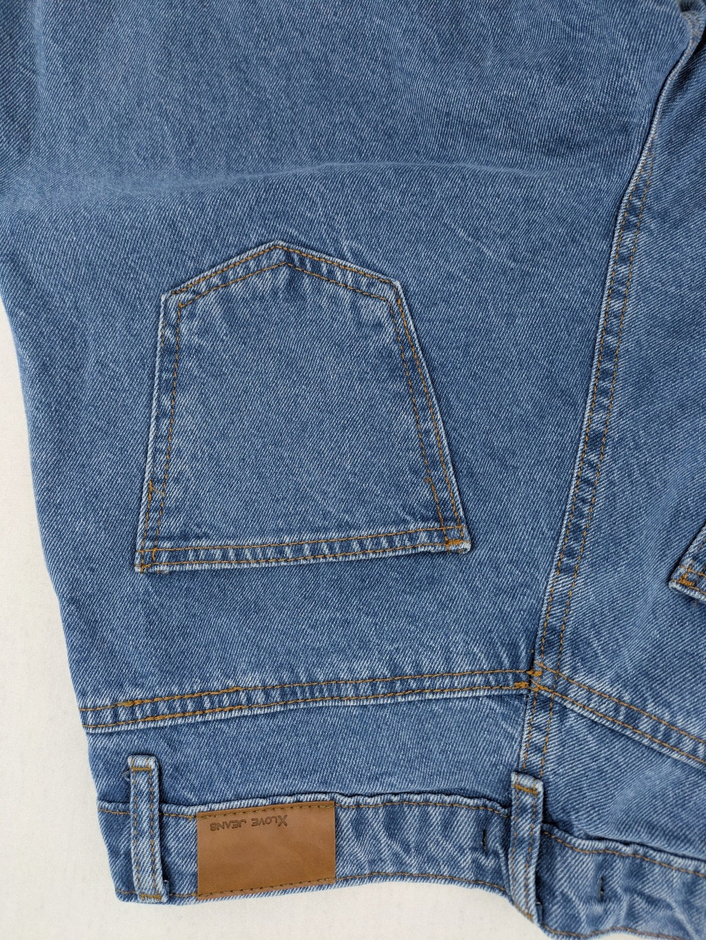 X.LOVE blue high waist wide leg jeans with front pleats and frayed hem.
