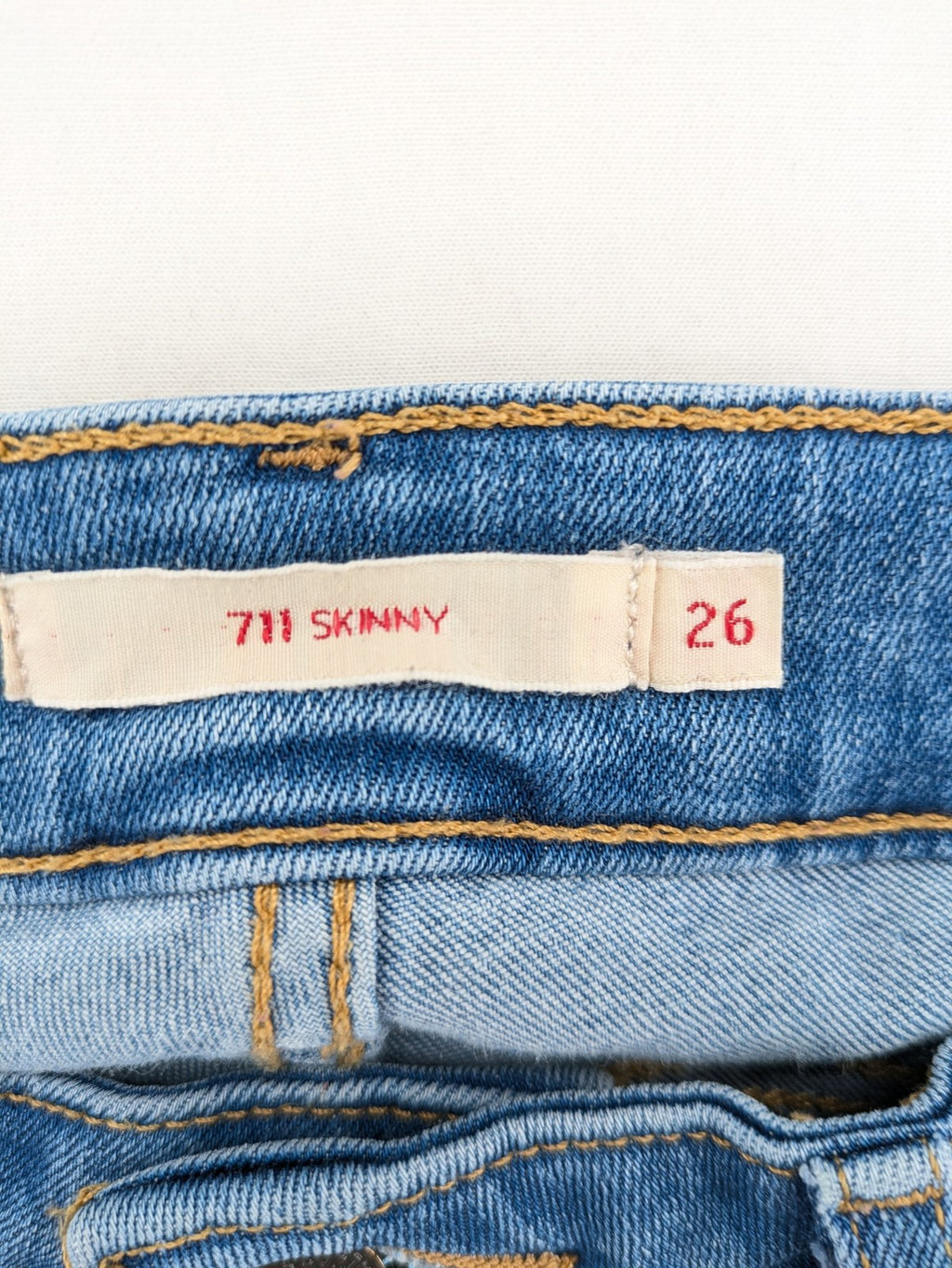 Levi's blue skinny jeans with raw hem, classic five-pocket design, and zip fly.
