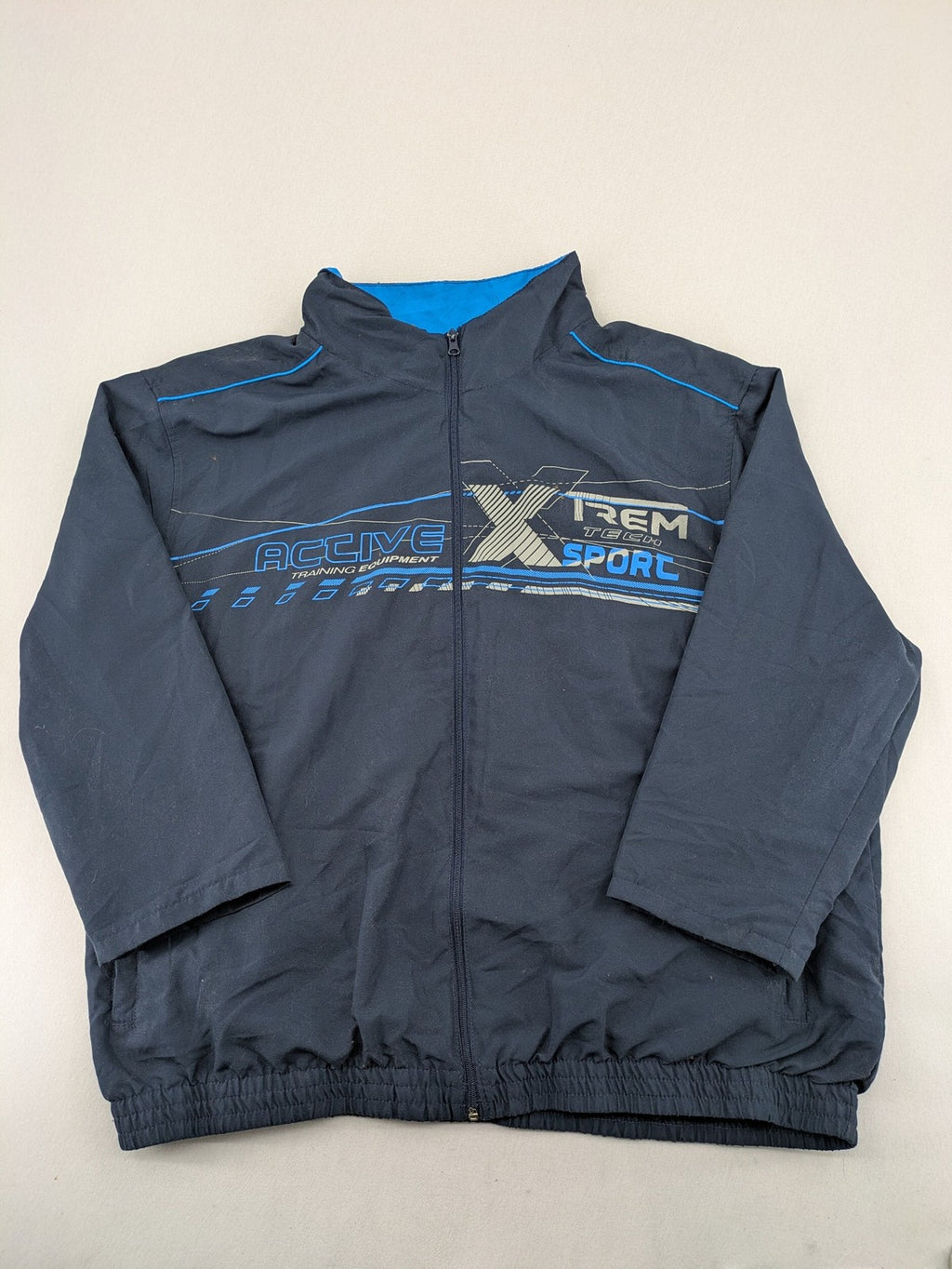 Atlas for Men blue windbreaker jacket with XTREM TECH SPORT graphic print and full zip.