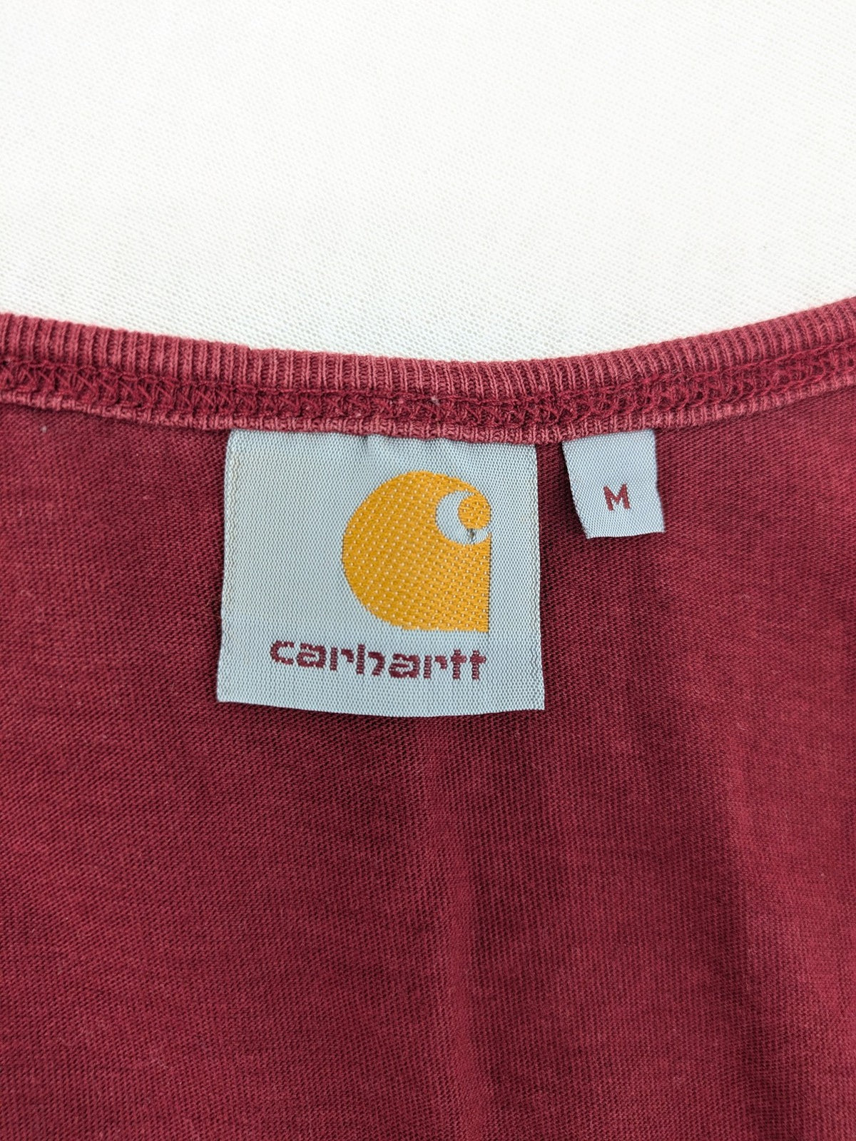 Carhartt burgundy tank top 100% cotton with iconic logo patch at hem.
