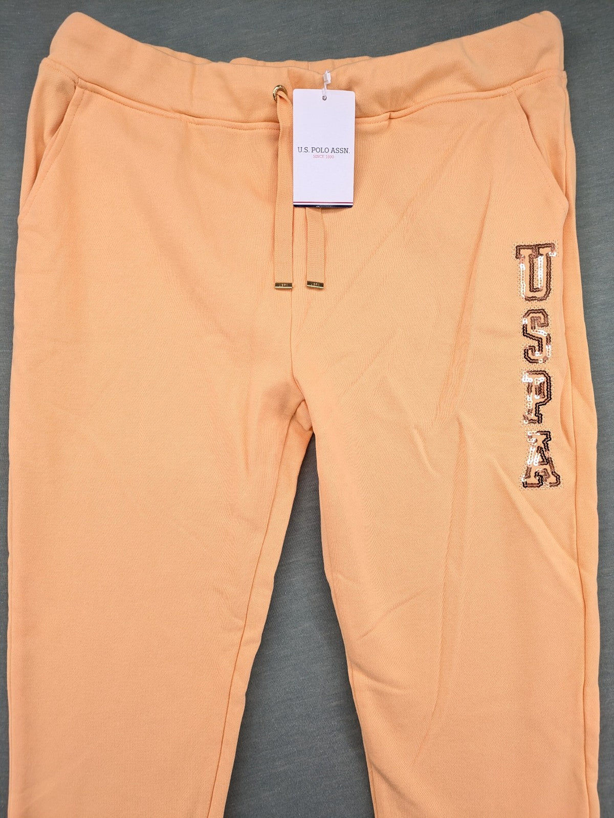 U.S. Polo Assn. orange sweatpants slim fit with sequin USPA logo on leg.