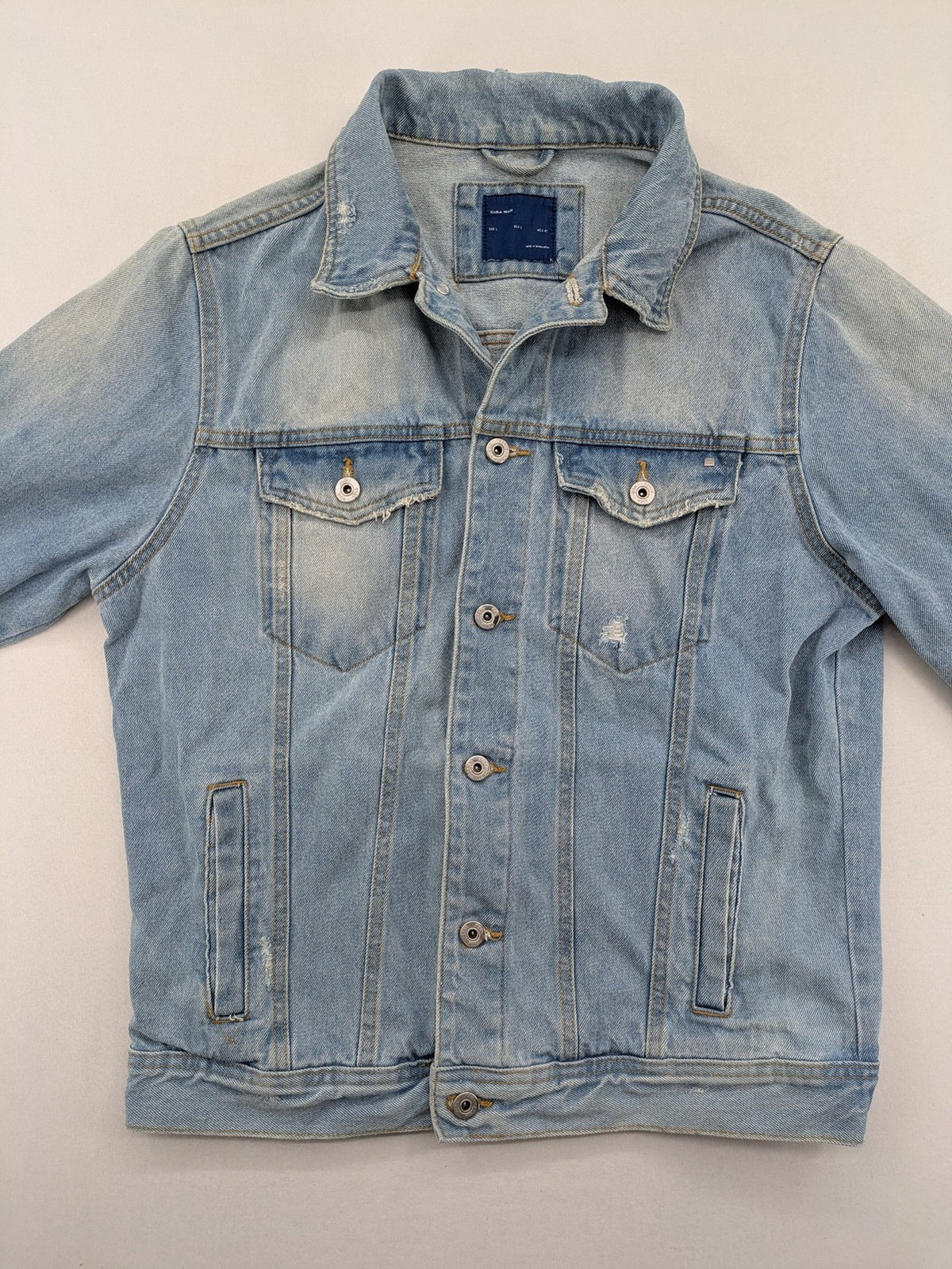 Zara Man blue denim jacket distressed with button closure and chest pockets.