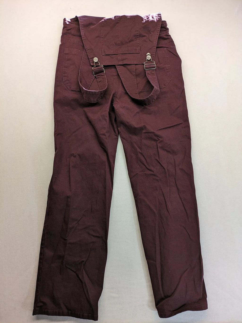 Kazane burgundy overalls with adjustable straps, side button placket, and chest pocket.