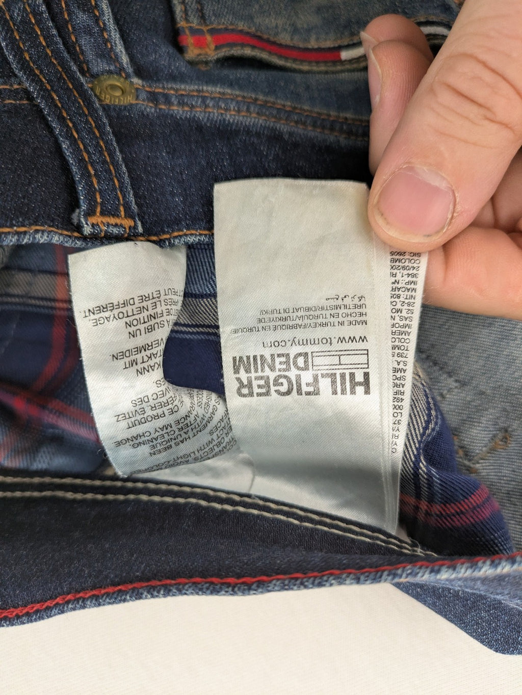 Tommy Hilfiger Denim blue straight jeans with five-pocket design and natural fading details.