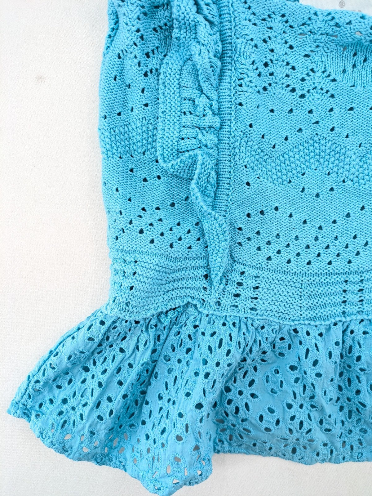 Springfield blue knit top with ruffled straps, peplum hem, and lace embroidery.