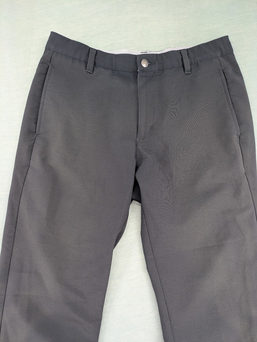 Adidas grey pants with 3-stripe logo, flat-front design, made from performance material.