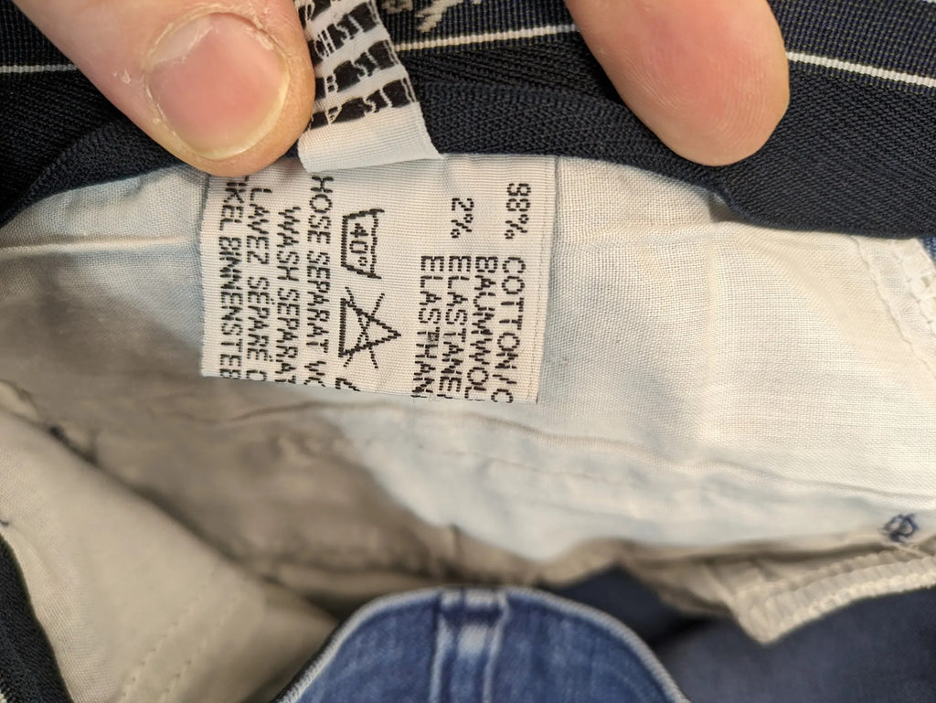 REI blue straight jeans with front pleats, zip fly, and buttoned back pockets.
