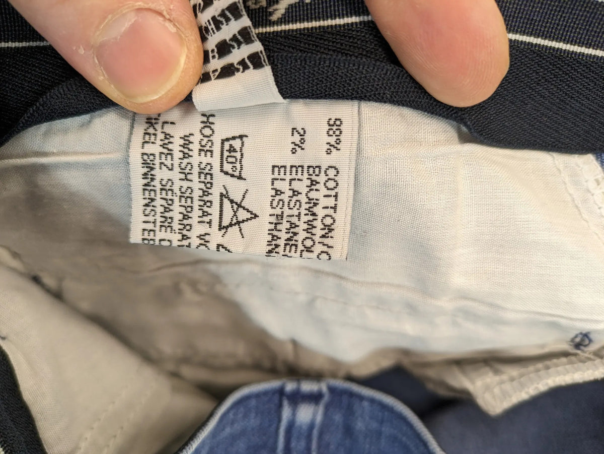 REI blue straight jeans with front pleats, zip fly, and buttoned back pockets.