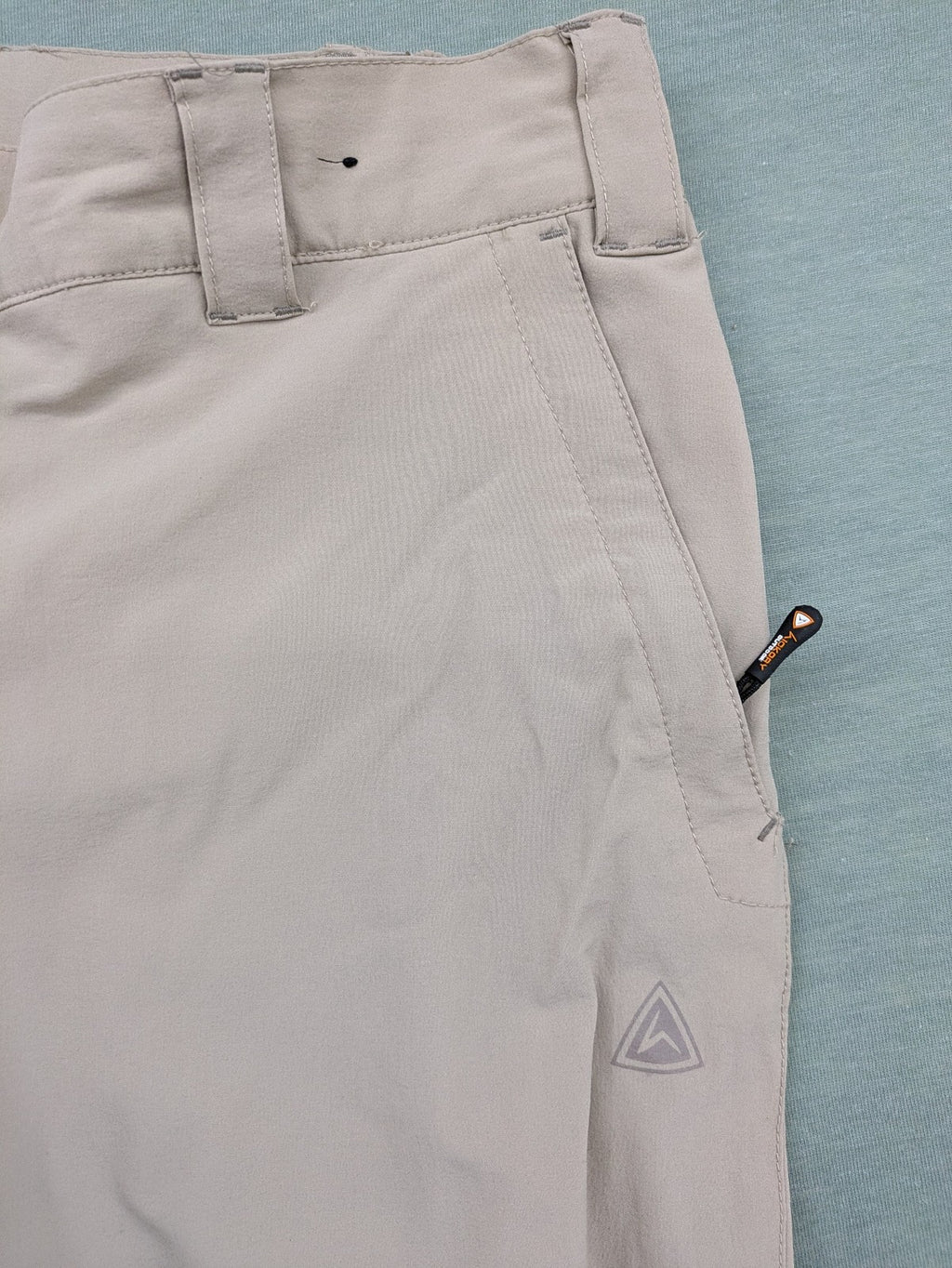Hickory beige outdoor pants with multiple zippered pockets and stretch fabric for comfort.