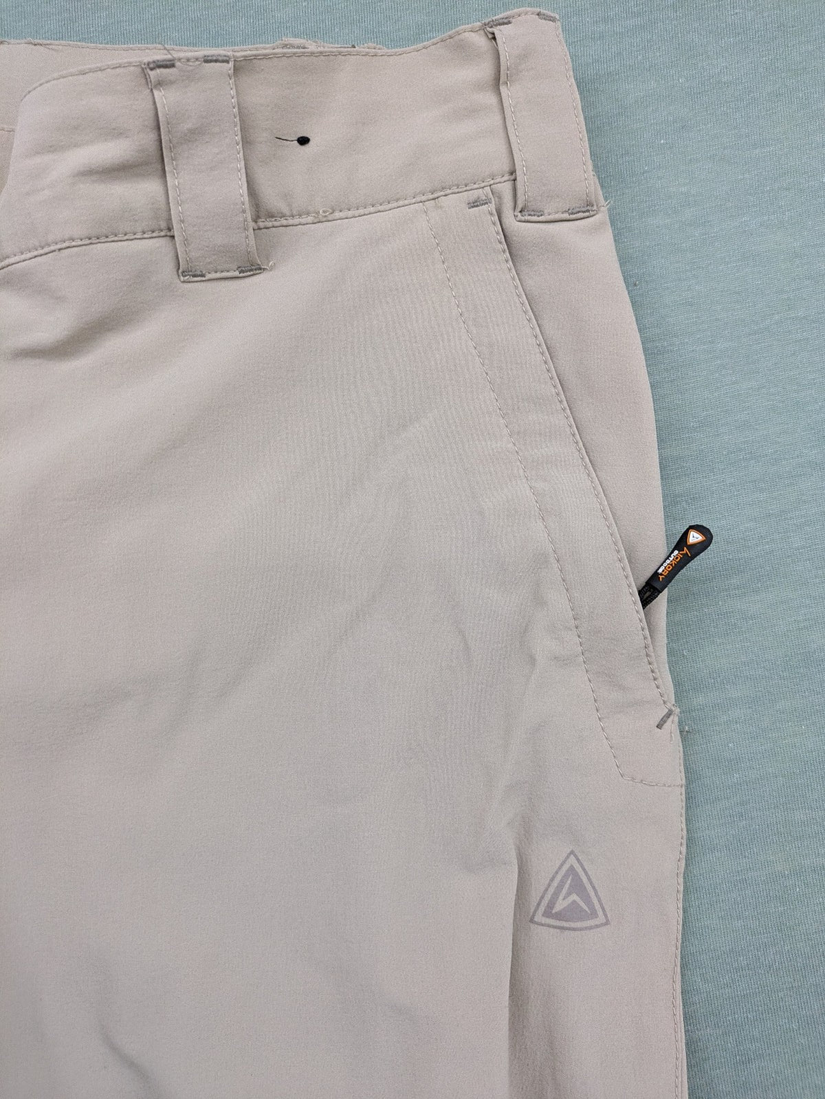 Hickory beige outdoor pants with multiple zippered pockets and stretch fabric for comfort.