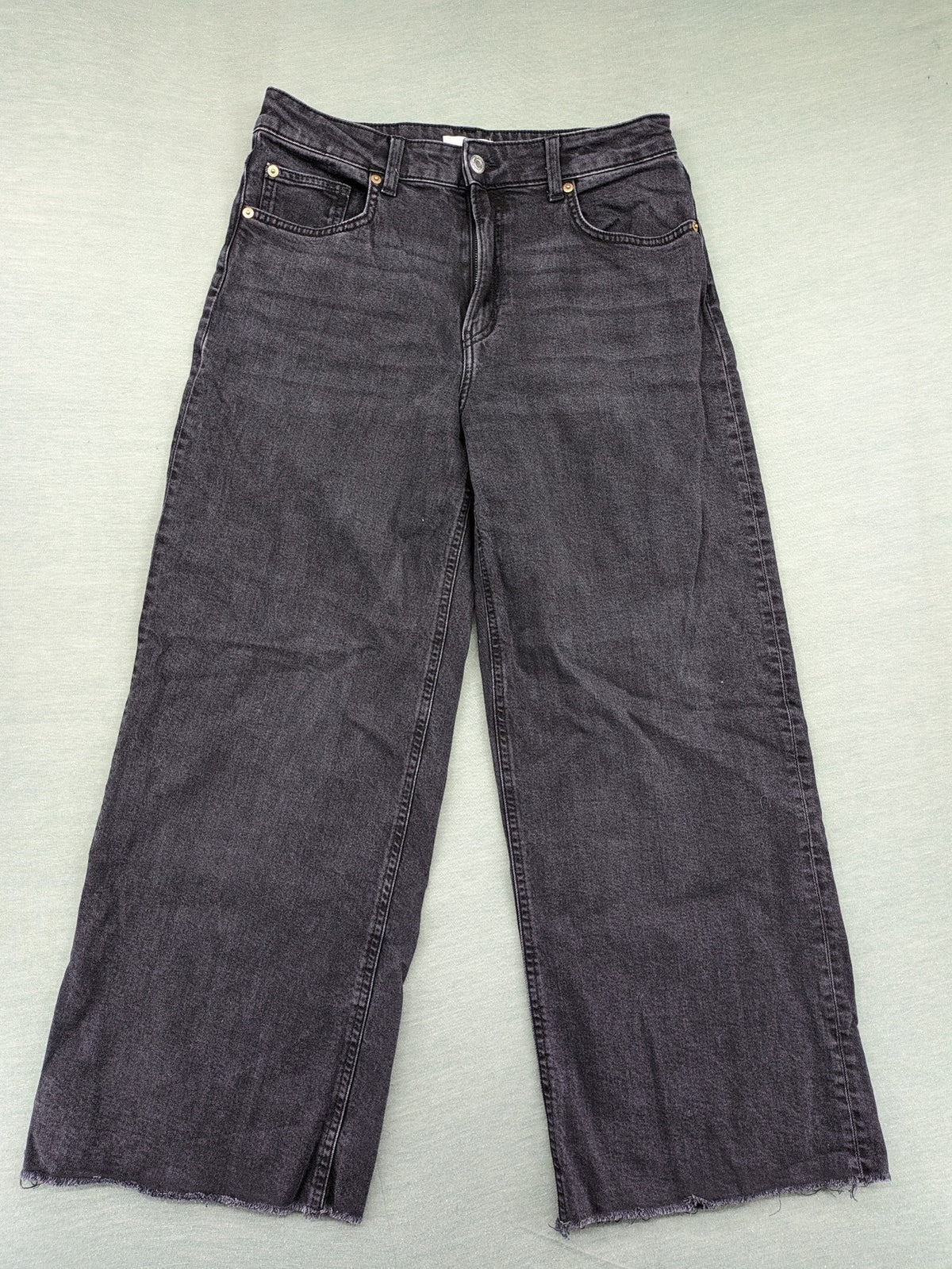 H&M black grey wide leg cropped jeans with frayed hem and high waist design.