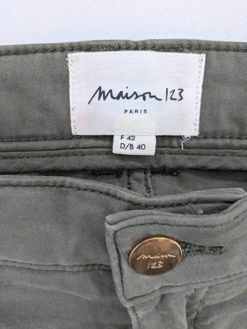 Maison 123 green cargo pants with ankle zippers and gold metal details.