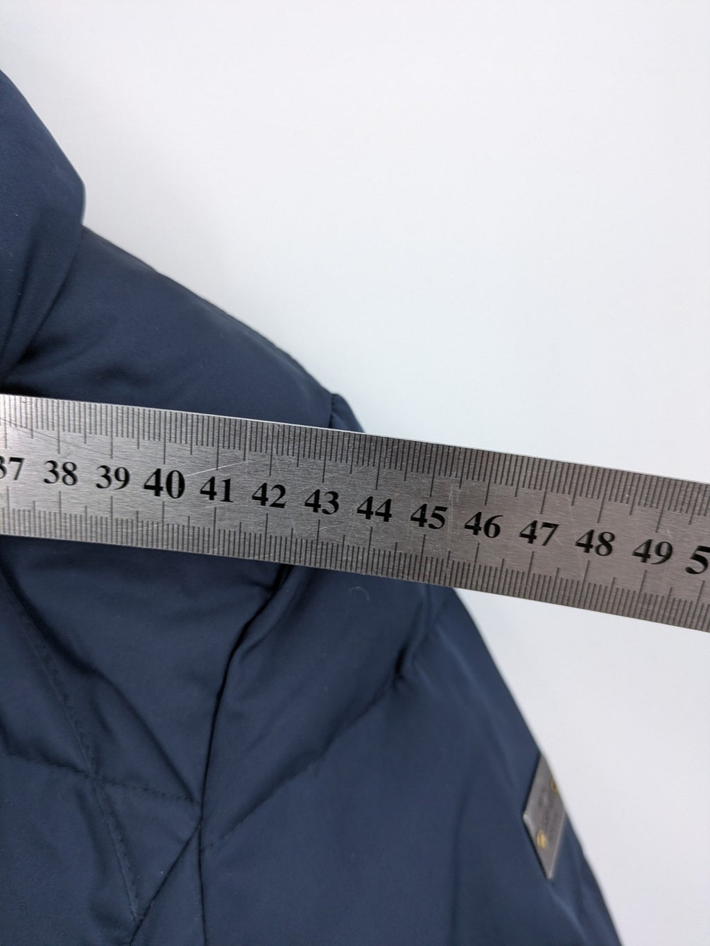 Esprit navy puffer jacket with belt, high collar, ribbed inner lining, and button placket.