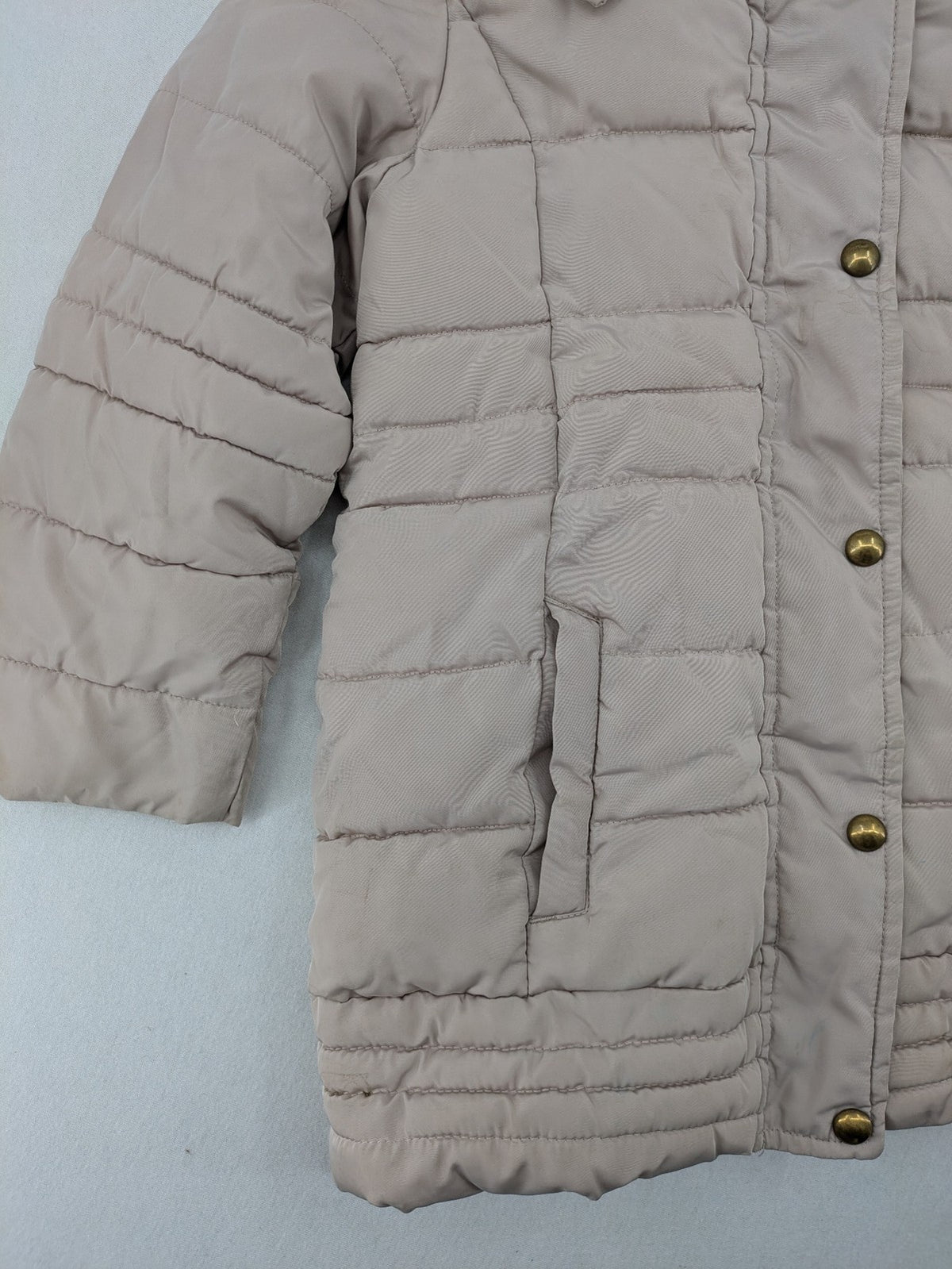 Brit Island beige puffer coat with fleece lining and faux fur hood detail.
