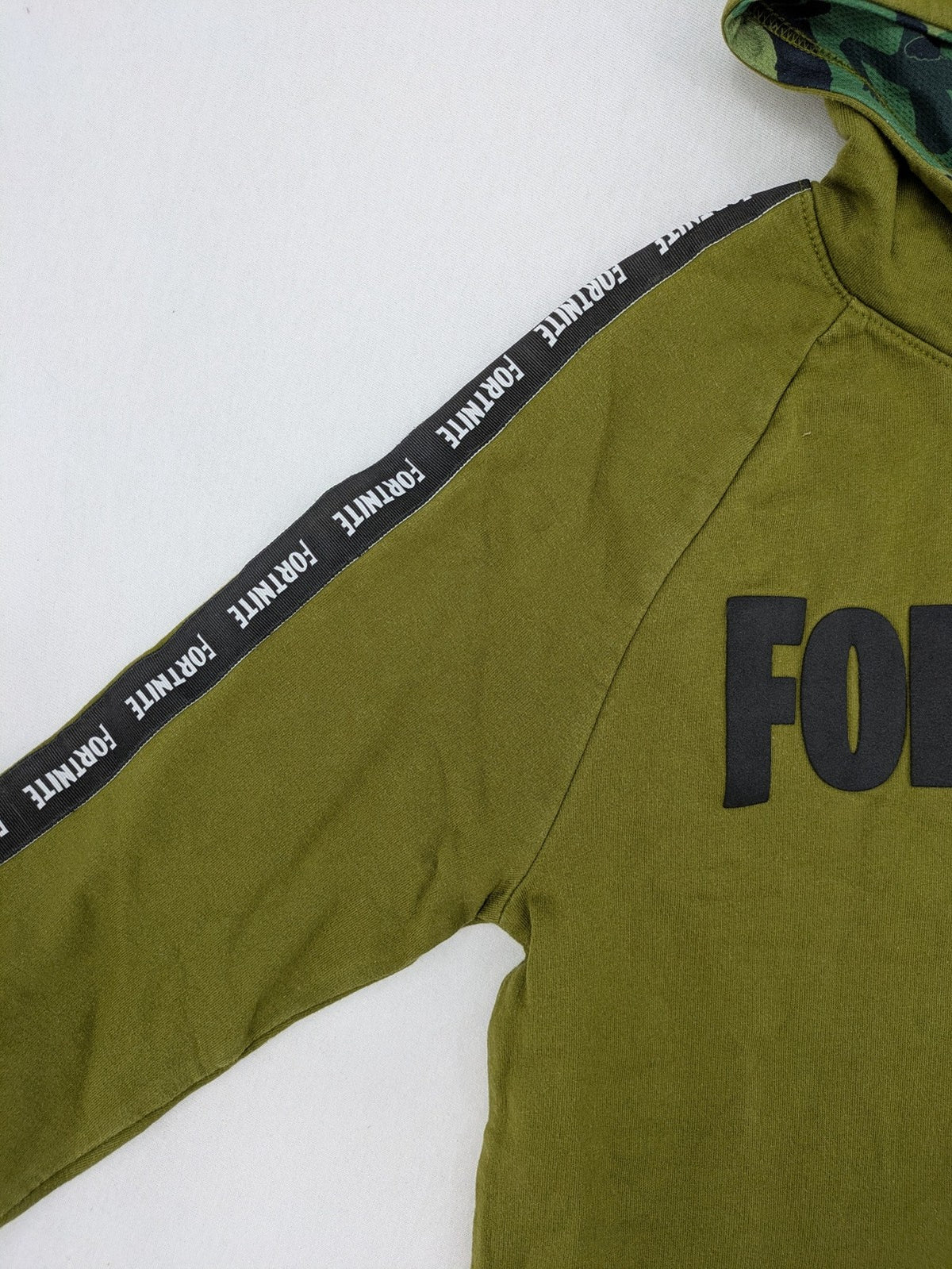 Fortnite green camo hoodie with black logo, contrasting hood, and logo taping on sleeves.
