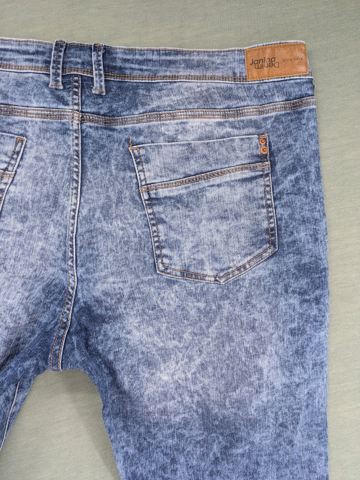 Janina blue slim fit jeans with acid wash, destroyed details, and button fly.