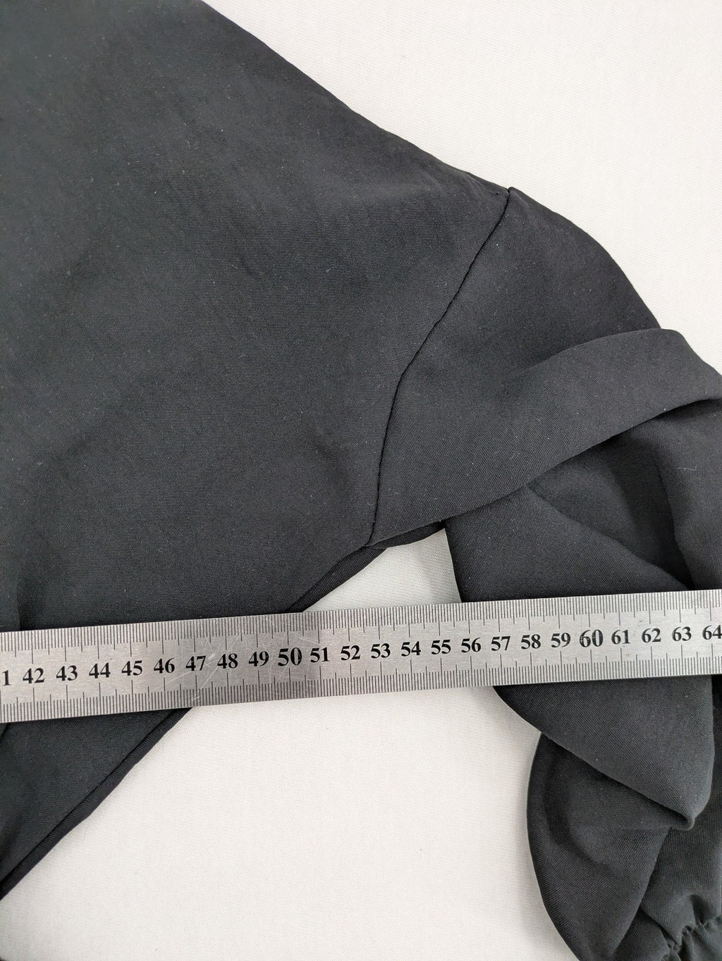 Bella black wrap blouse with deep V-neck and ruffled long sleeves.