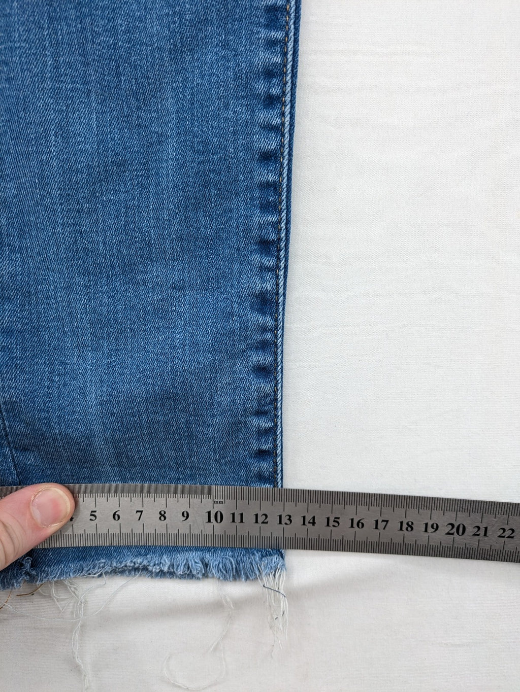 Levi's blue skinny jeans with raw hem, classic five-pocket design, and zip fly.